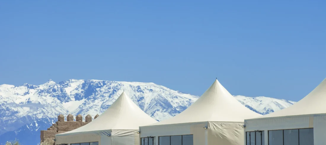 Sunset view of The White Camel agafay luxury camp with Atlas Mountains backdrop