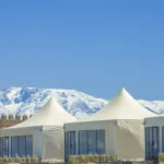 Sunset view of The White Camel agafay luxury camp with Atlas Mountains backdrop