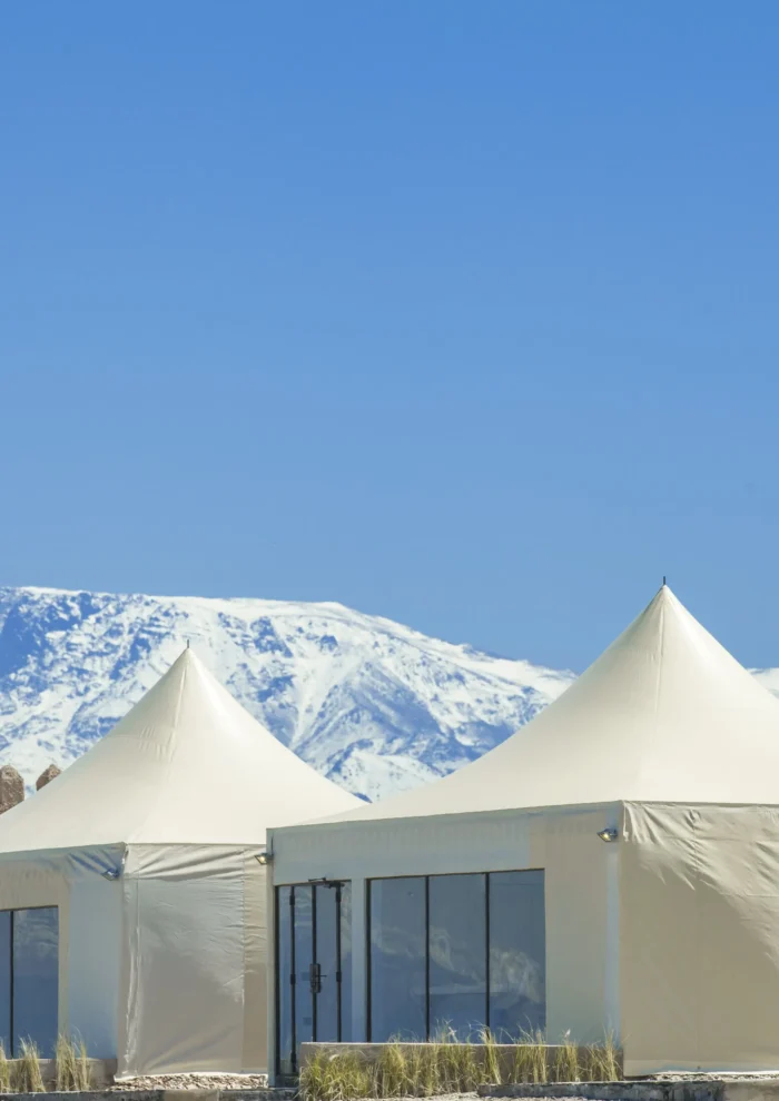 Sunset view of The White Camel agafay luxury camp with Atlas Mountains backdrop